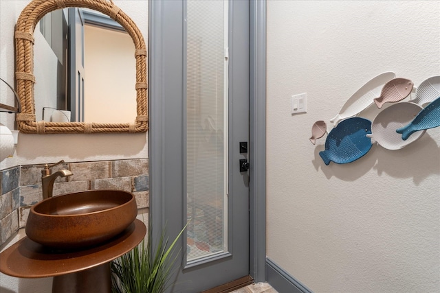 bathroom with tasteful backsplash and sink