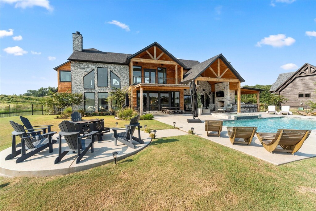 view of swimming pool featuring an in ground hot tub, outdoor lounge area, a patio, and a lawn