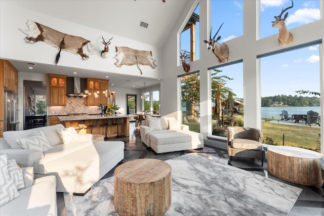 living room with a water view and high vaulted ceiling