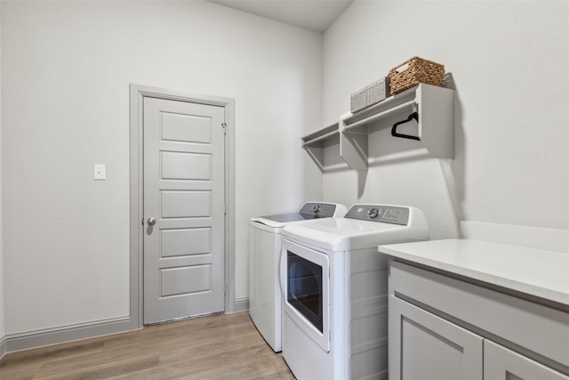 laundry area with washer and dryer and light hardwood / wood-style floors