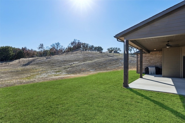 view of yard with ceiling fan and a patio