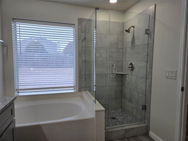 bathroom with independent shower and bath and vanity