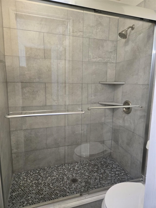 bathroom with toilet and an enclosed shower