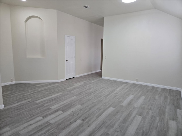 empty room with lofted ceiling and light wood-type flooring