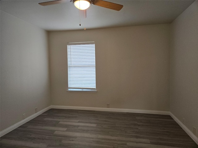 empty room with ceiling fan and dark hardwood / wood-style flooring