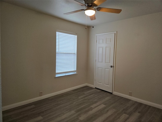 spare room with dark hardwood / wood-style floors and ceiling fan