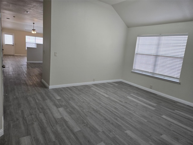 empty room with ceiling fan, lofted ceiling, and dark hardwood / wood-style flooring