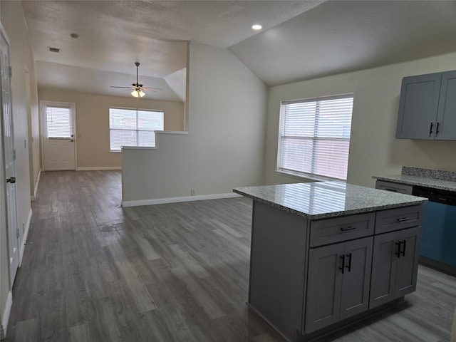 kitchen with lofted ceiling, gray cabinetry, a center island, dark hardwood / wood-style floors, and dishwasher