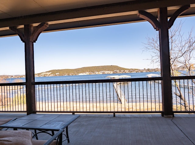 view of patio / terrace with a water and mountain view and a balcony