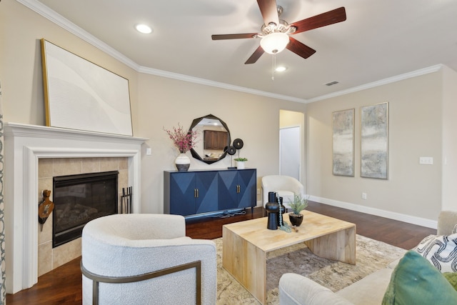 living room featuring dark hardwood / wood-style flooring, ceiling fan, crown molding, and a fireplace