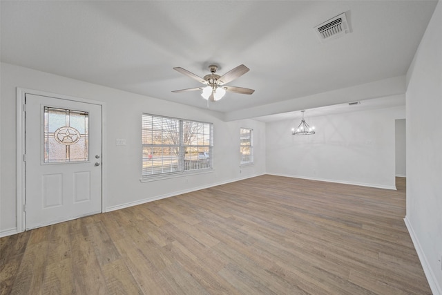 interior space featuring hardwood / wood-style flooring and ceiling fan with notable chandelier