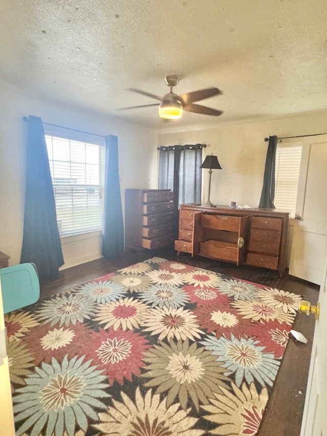 bedroom with ceiling fan and a textured ceiling