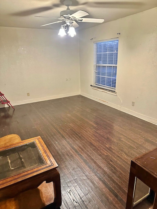 empty room featuring dark wood-type flooring and ceiling fan