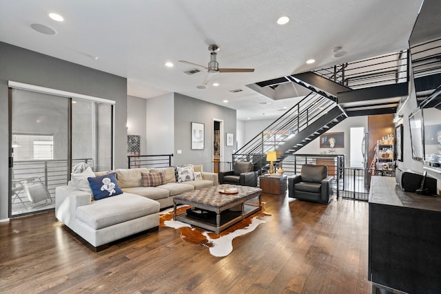 living room featuring ceiling fan, dark hardwood / wood-style floors, and a textured ceiling