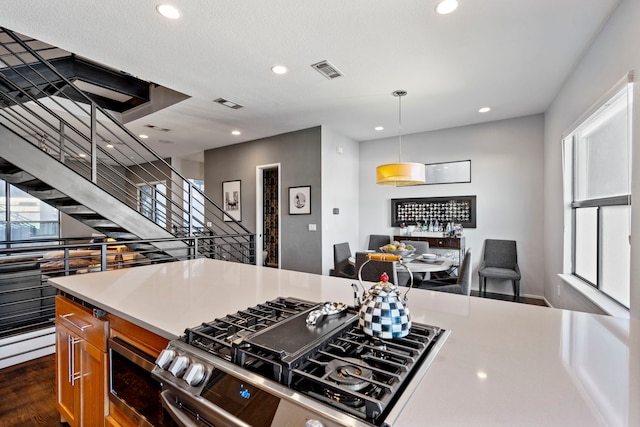 kitchen featuring pendant lighting, dark hardwood / wood-style floors, and stainless steel gas stove