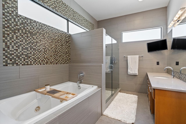 bathroom featuring vanity, tile patterned flooring, tile walls, and separate shower and tub