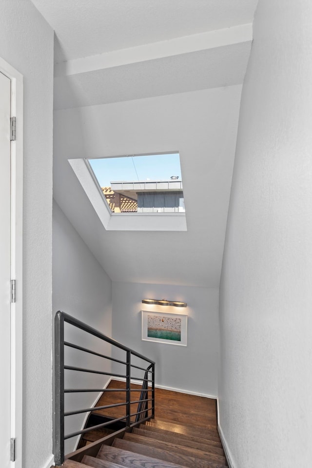 stairs with vaulted ceiling and hardwood / wood-style floors