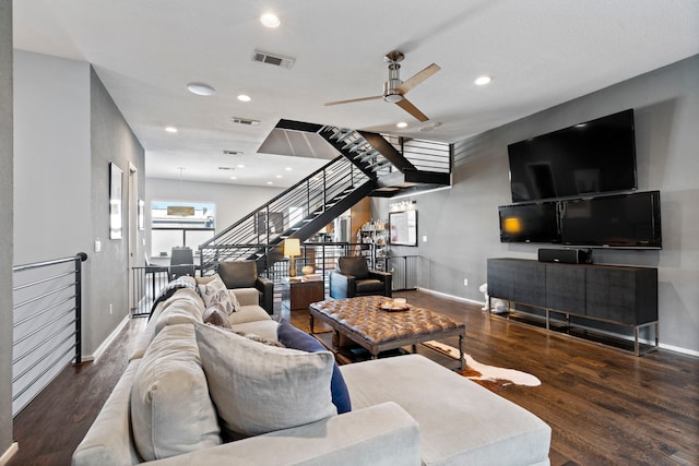 living room featuring dark wood-type flooring and ceiling fan