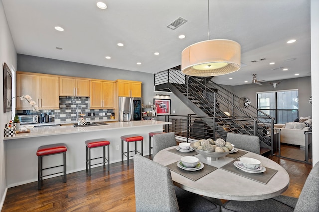 dining area with dark wood-type flooring and ceiling fan