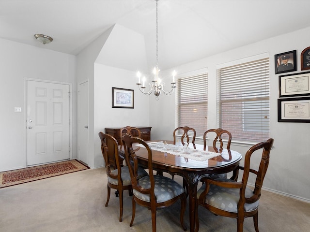 carpeted dining area with an inviting chandelier