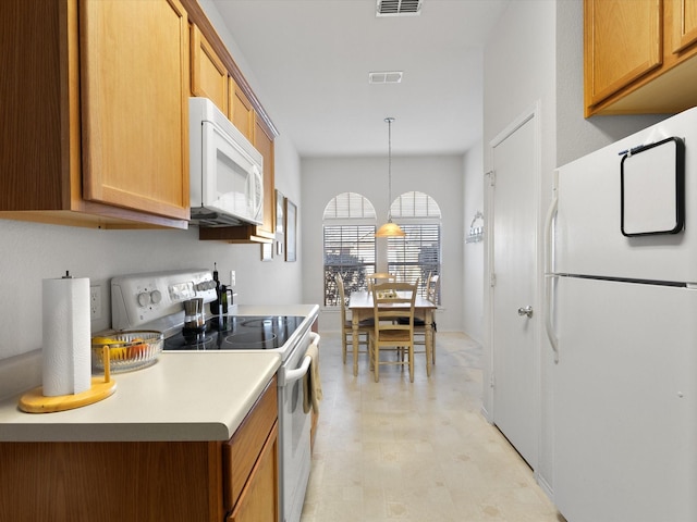 kitchen featuring hanging light fixtures and white appliances