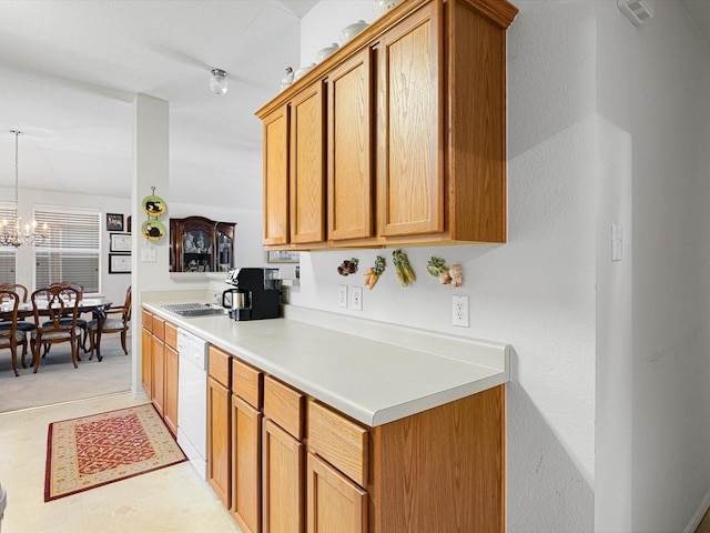 kitchen with an inviting chandelier, white dishwasher, and sink