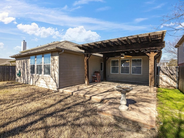 rear view of property with ceiling fan, a patio area, and a lawn