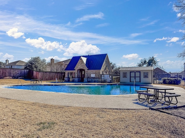 view of swimming pool with an outdoor structure and a patio