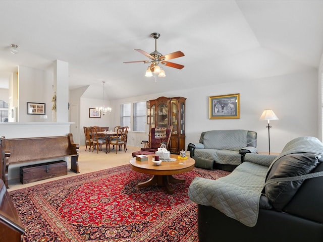 carpeted living room featuring vaulted ceiling and ceiling fan with notable chandelier