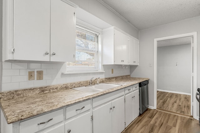 kitchen featuring sink, dishwasher, white cabinetry, a textured ceiling, and decorative backsplash