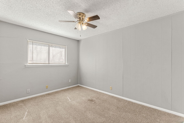 empty room featuring ceiling fan, carpet flooring, and a textured ceiling