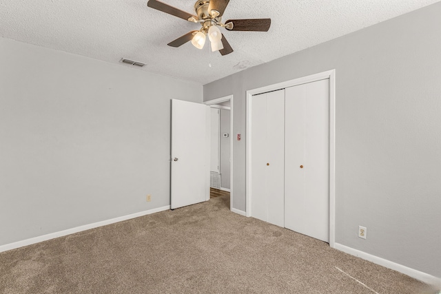 unfurnished bedroom featuring carpet floors, a textured ceiling, ceiling fan, and a closet