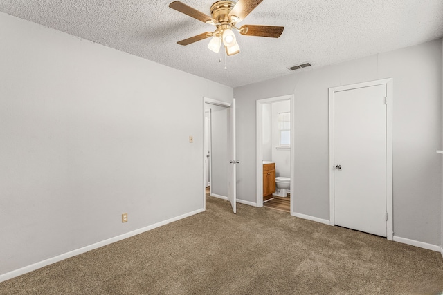 unfurnished bedroom featuring a textured ceiling, carpet, ceiling fan, and ensuite bathroom