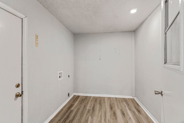 clothes washing area featuring washer hookup, hookup for an electric dryer, light hardwood / wood-style floors, and a textured ceiling