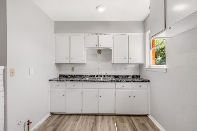 kitchen with sink, dark stone counters, and white cabinets