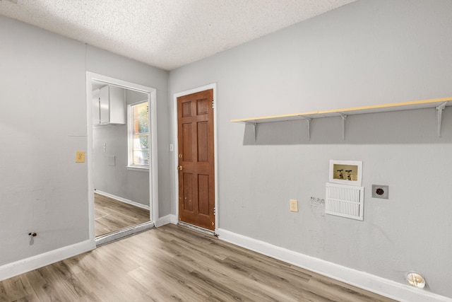 laundry room with washer hookup, hookup for an electric dryer, wood-type flooring, and a textured ceiling