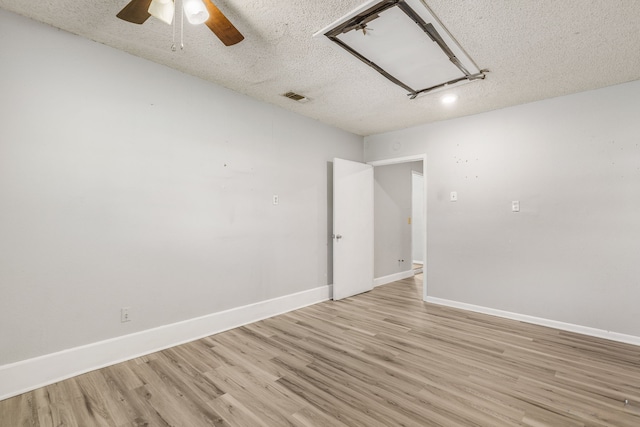 empty room featuring ceiling fan, light hardwood / wood-style flooring, and a textured ceiling