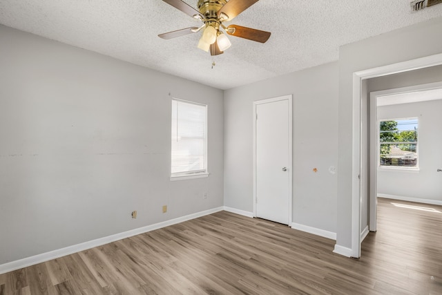 unfurnished bedroom featuring a textured ceiling, ceiling fan, and hardwood / wood-style flooring