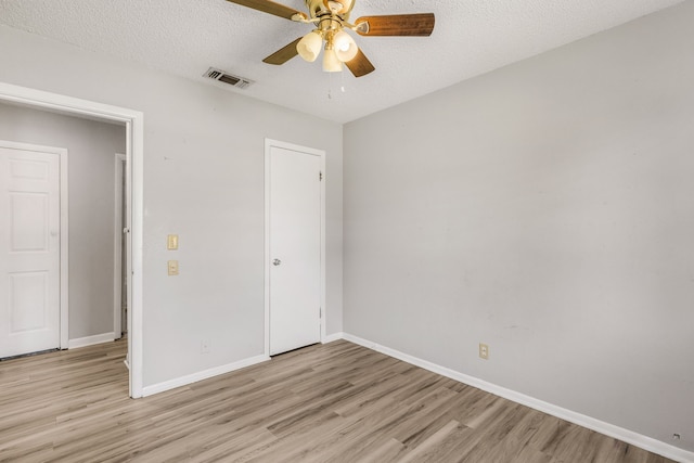 unfurnished bedroom with a textured ceiling, light hardwood / wood-style floors, and ceiling fan