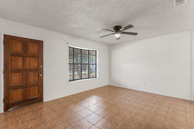 entryway featuring a textured ceiling, ceiling fan, and light tile patterned flooring