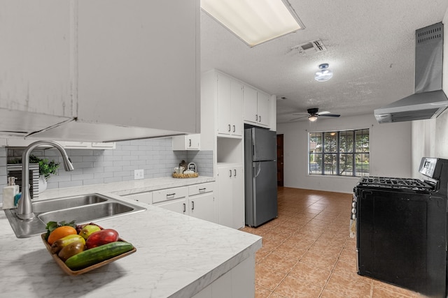 2920 Cunningham Dr, Wichita Falls, TX 76308 - kitchen featuring ventilation hood, white cabinetry, sink, stainless steel fridge, and gas stove