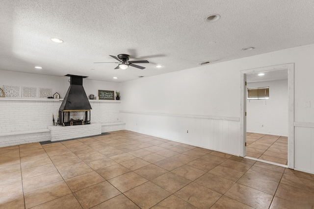 2920 Cunningham Dr, Wichita Falls, TX 76308 - unfurnished living room featuring light tile patterned flooring, ceiling fan, a textured ceiling, and a wood stove