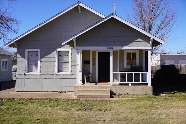 bungalow with covered porch and a front lawn