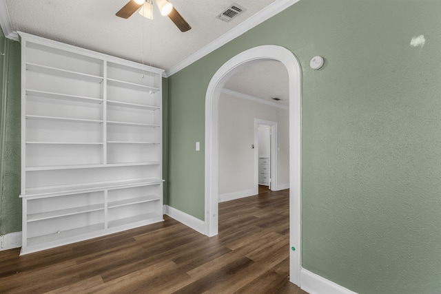 unfurnished room featuring a textured ceiling, ornamental molding, dark hardwood / wood-style floors, built in features, and ceiling fan