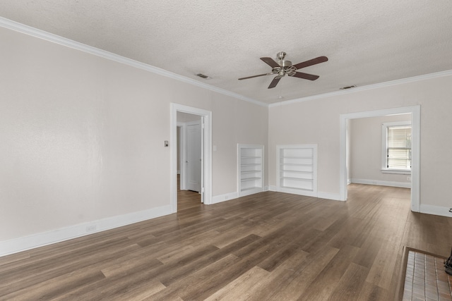 empty room featuring a textured ceiling, ornamental molding, dark hardwood / wood-style floors, built in features, and ceiling fan