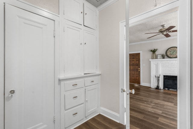 hallway featuring ornamental molding, dark hardwood / wood-style flooring, and a textured ceiling