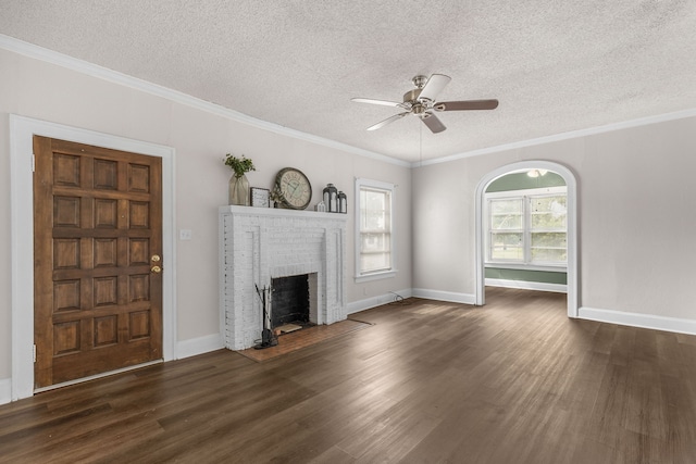 unfurnished living room with dark wood-type flooring, crown molding, a textured ceiling, ceiling fan, and a fireplace