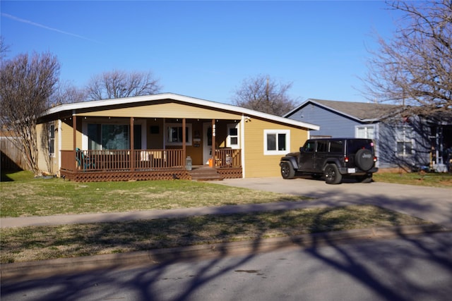 ranch-style house featuring a porch and a front yard