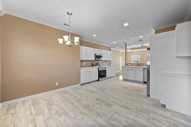 kitchen featuring backsplash, crown molding, white cabinets, and appliances with stainless steel finishes