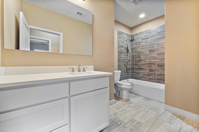 full bathroom featuring tiled shower / bath, vanity, and toilet